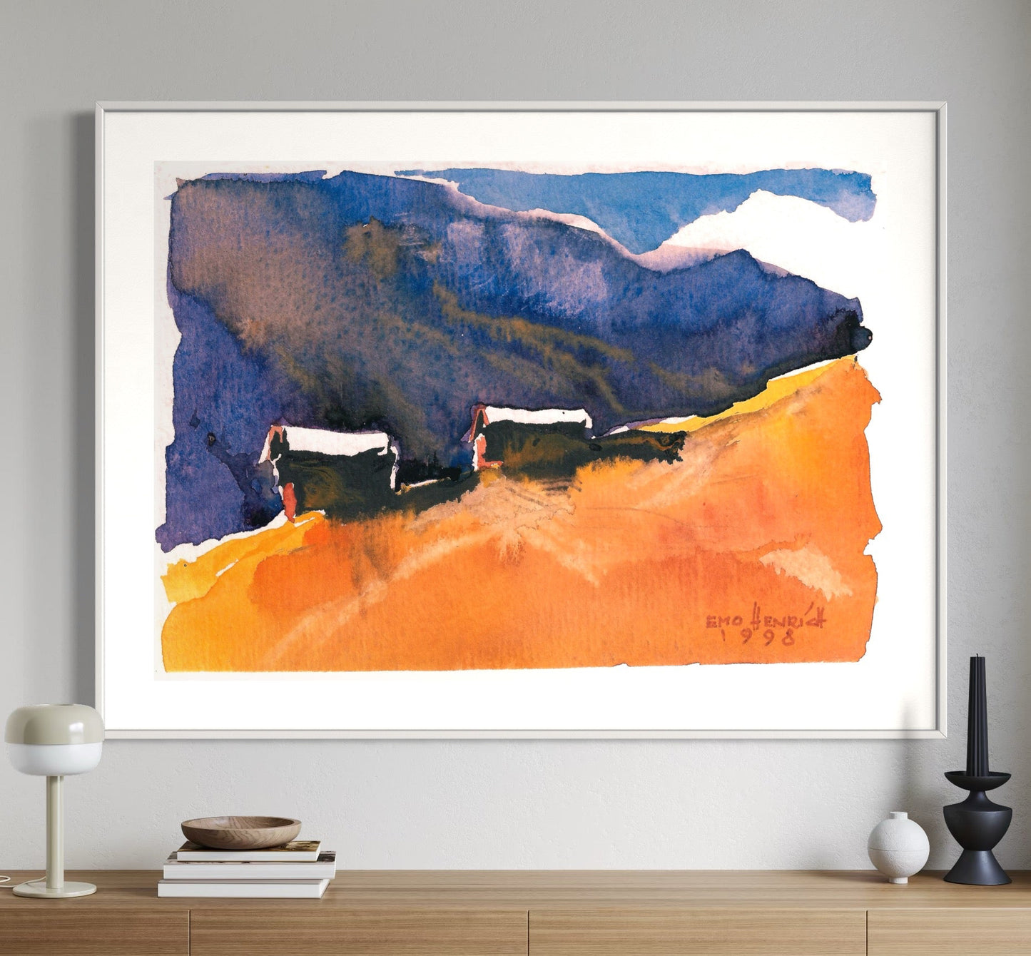 A framed watercolor painting titled 'Landschaft II' displayed on a wall above a wooden console table, featuring abstract landscape in blue and orange hues.