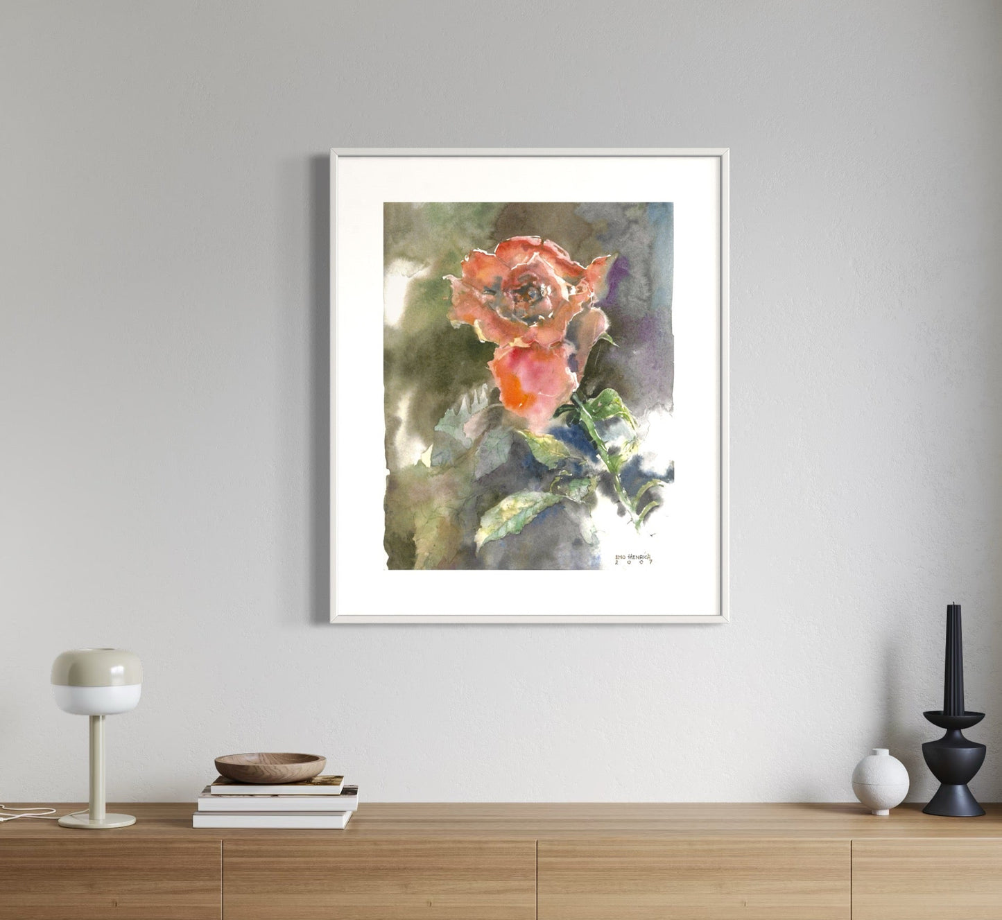 Framed floral artwork on a wall above a wooden cabinet.