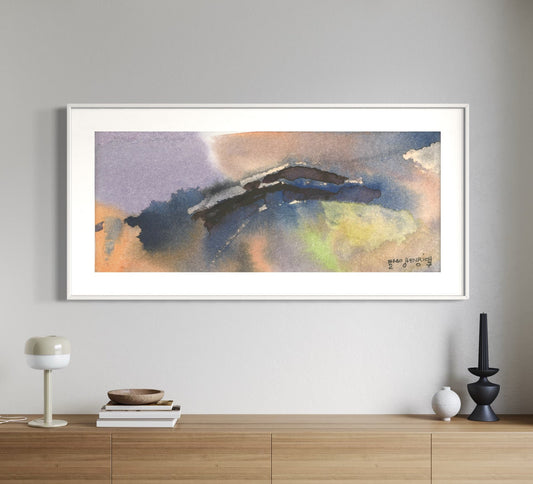 A framed watercolor painting depicting abstract mountainous landscape in shades of blue and yellow, hung on a wall above a wooden console table.