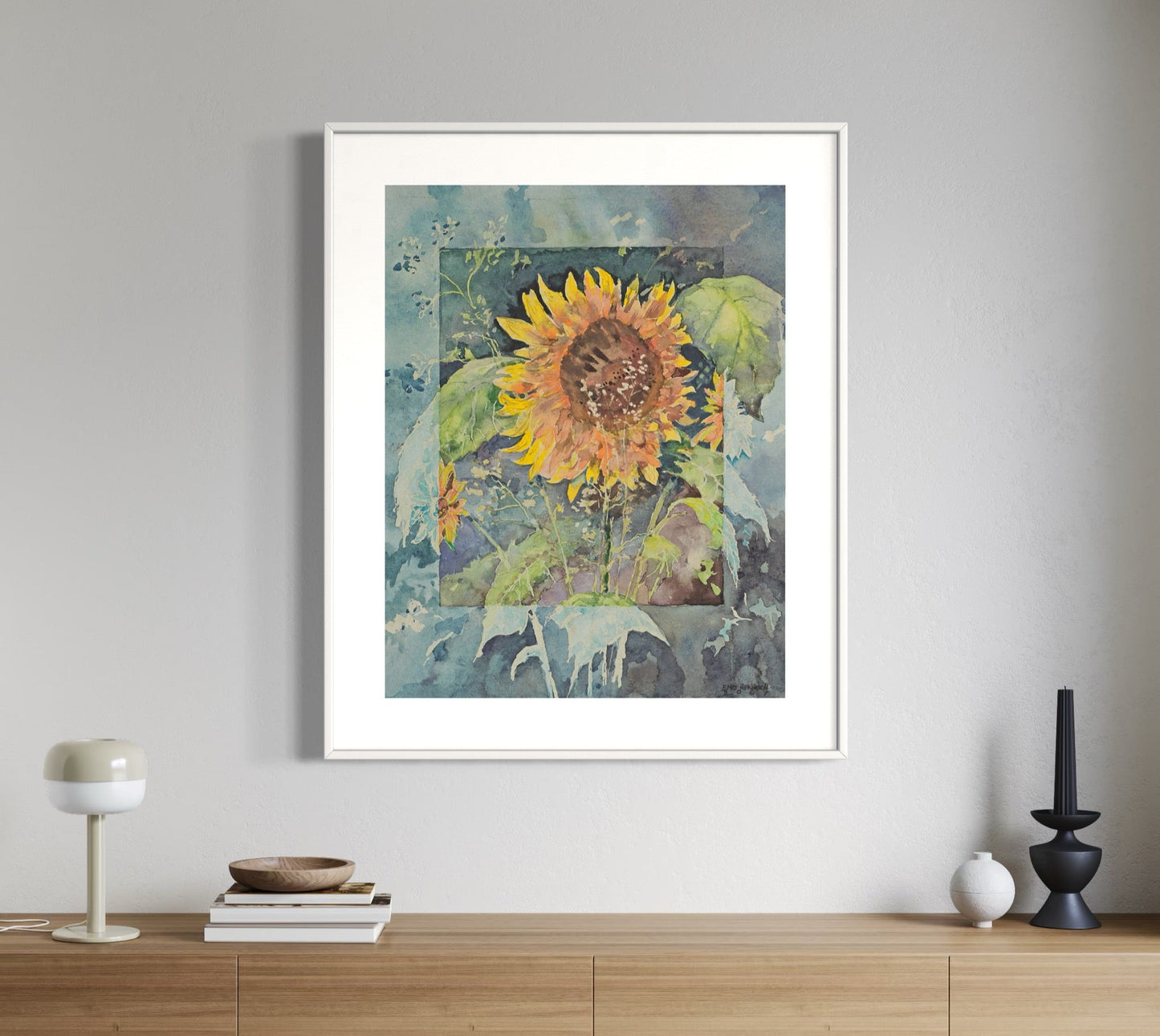 A framed painting of a sunflower displayed on a wooden wall shelf in a room with a light decor.