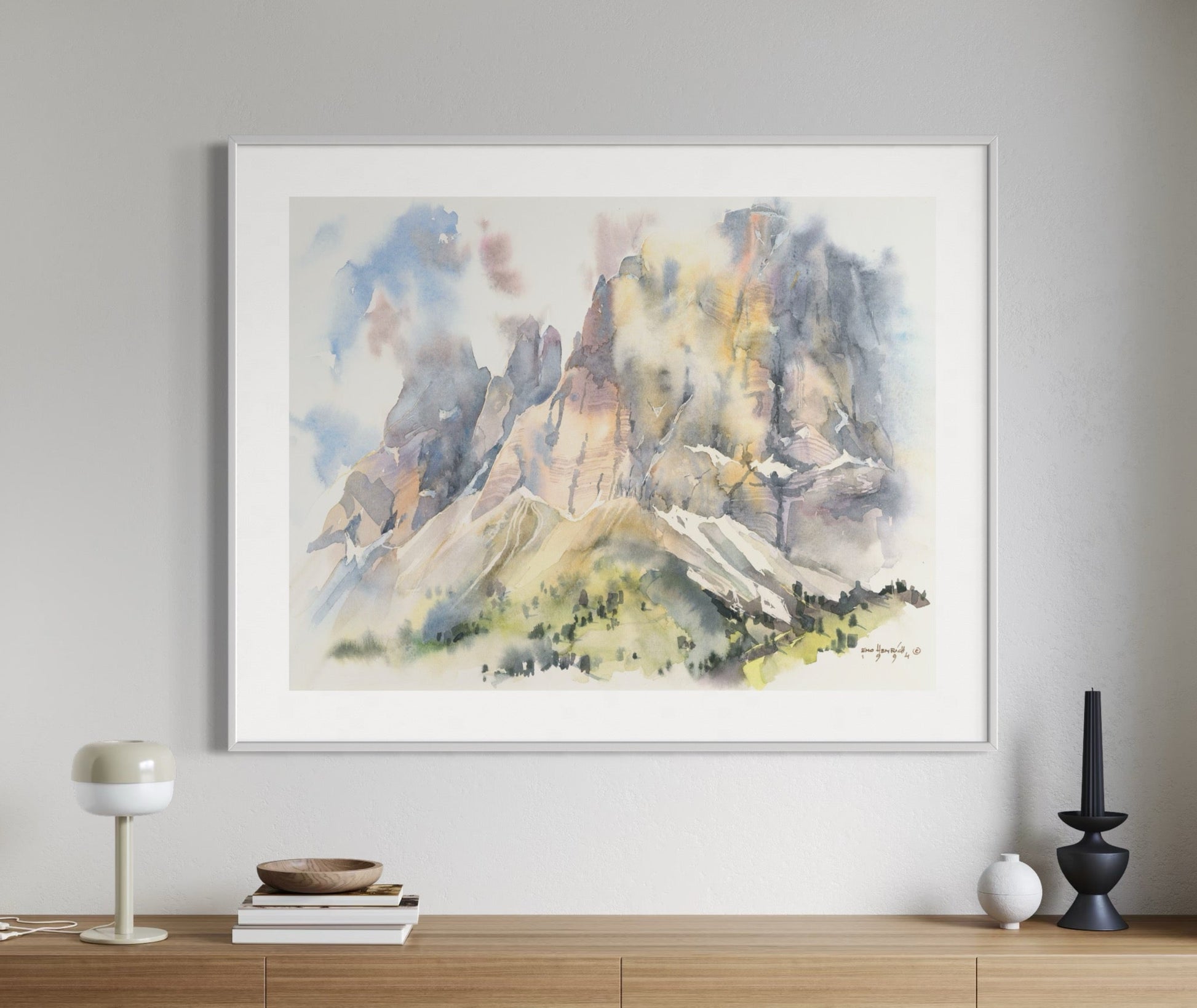 Framed abstract mountain painting above a wooden console table in a modern interior.