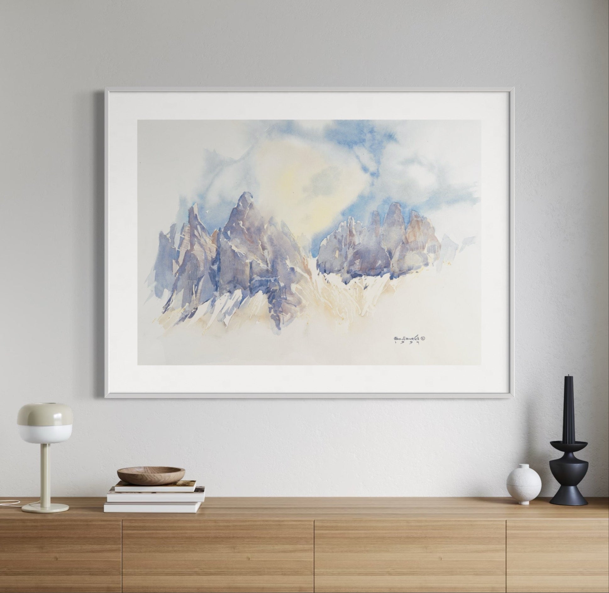 Framed abstract art piece on a wall above a wooden console table.